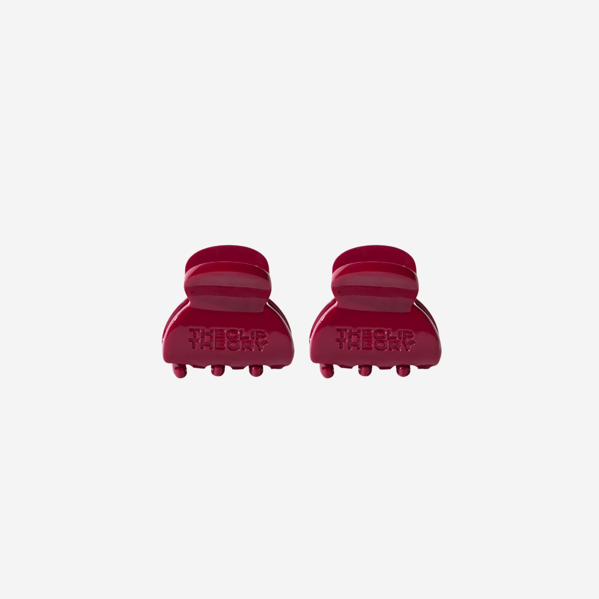 Two red hair clips on a white background